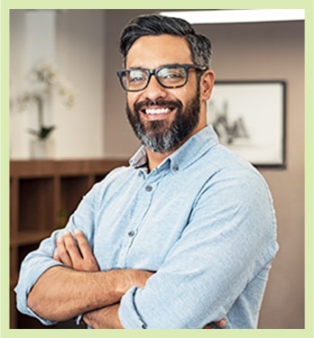 Man with salt & pepper beard crosses his arms with confidence