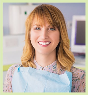 red haired woman shows off her smile after another great dental checkup